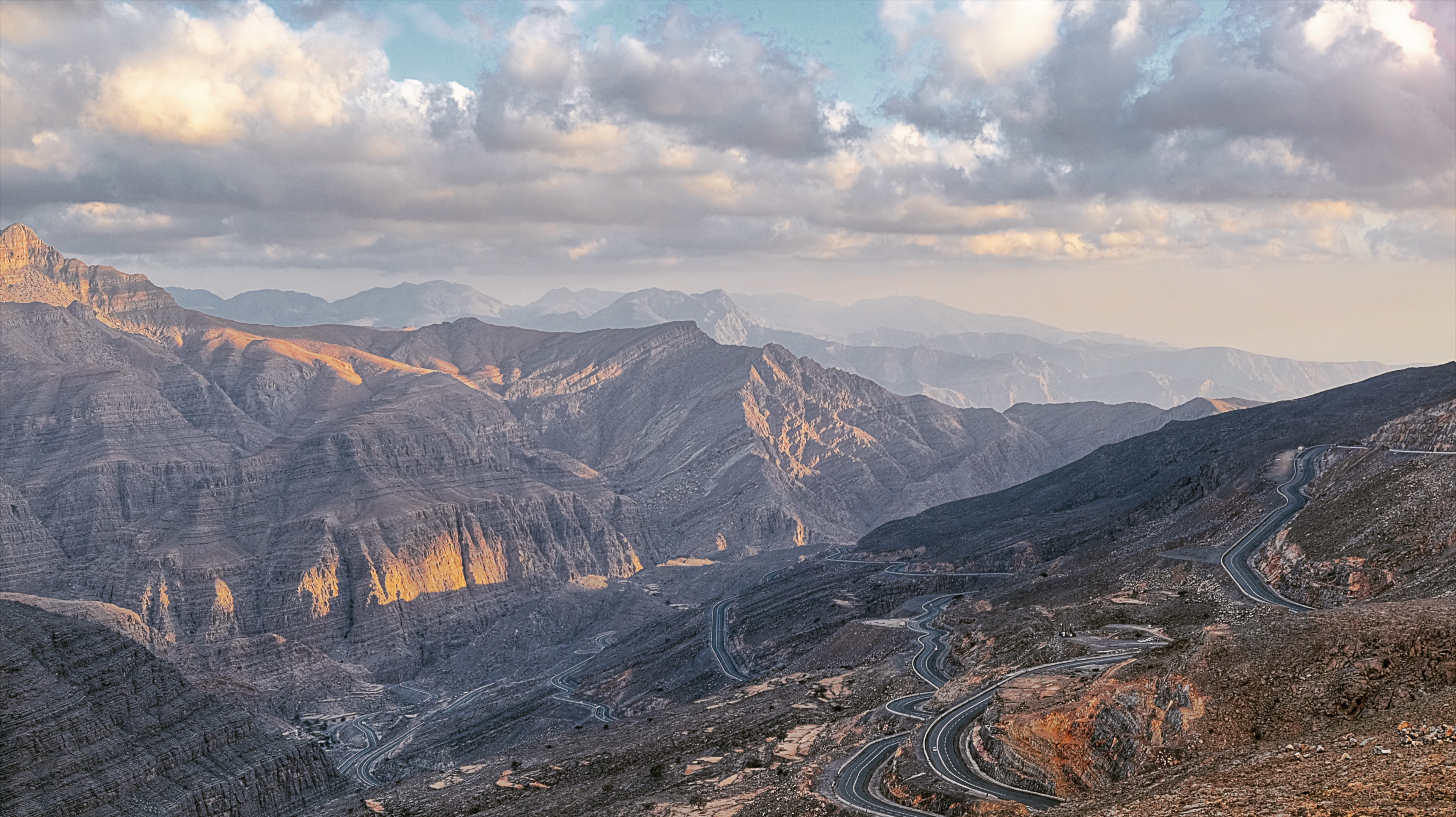 Breathtaking view of Jebel Jais mountains with winding roads and clear blue sky
